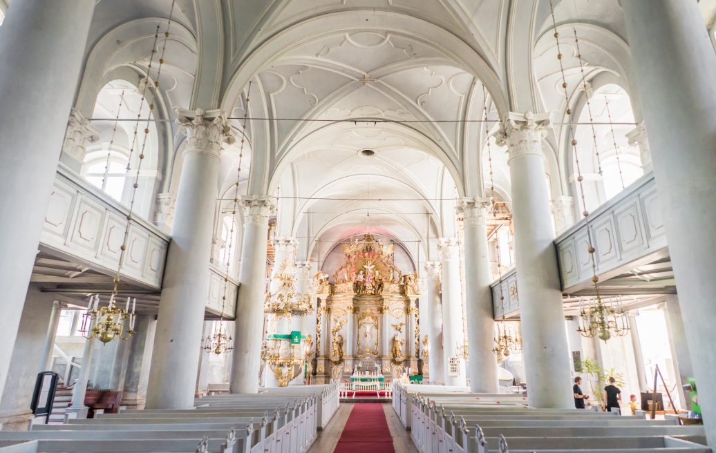 The interior of Liepāja's Holy Trinity Cathedral shows an exquisite design with luxurious gold elements and a white exterior.