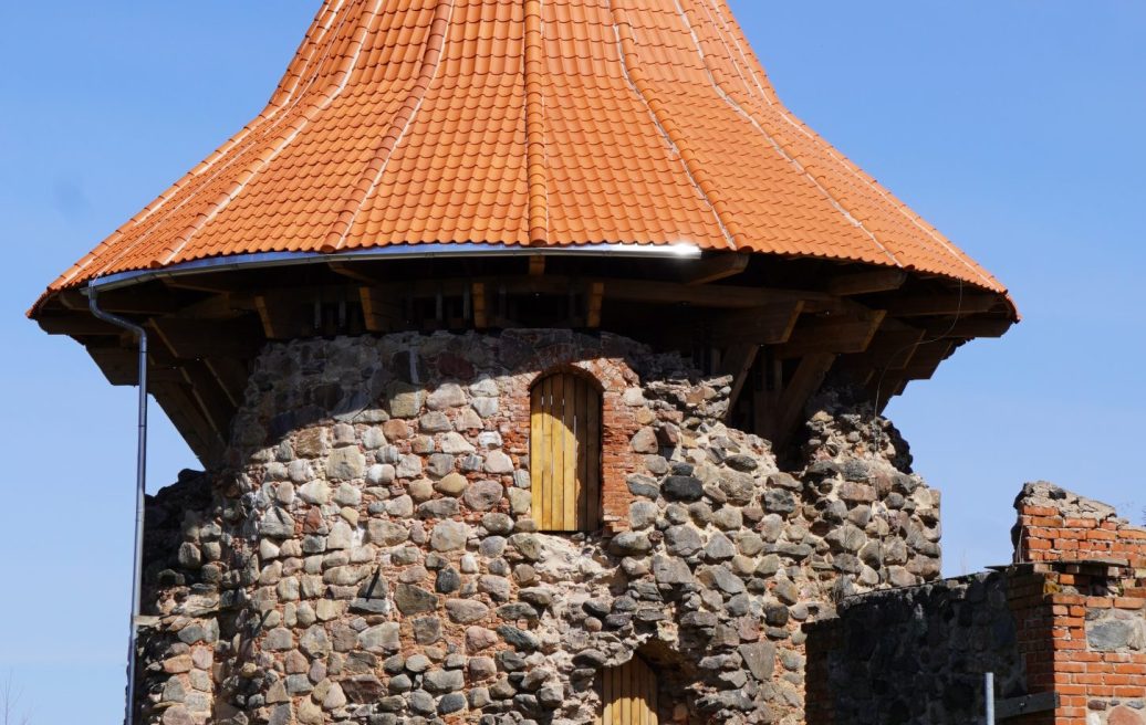Northern Tower of Ērģeme Medieval Castle with a tower spire in brown-orange color