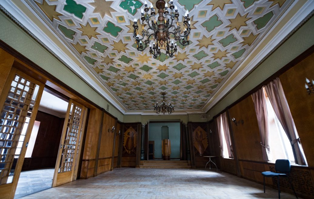 The main room of Sigulda New Palace with two chandeliers and a luxurious ceiling design