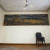 Siguldas Jaunās pils telpa ar mākslas darbu pie sienas un sēžamkrēsliem