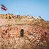 Bauskas castle tower close-up with the Latvian flag on top