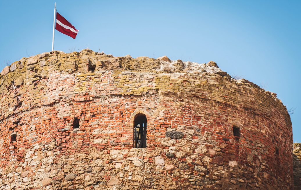 Bauskas castle tower close-up with the Latvian flag on top