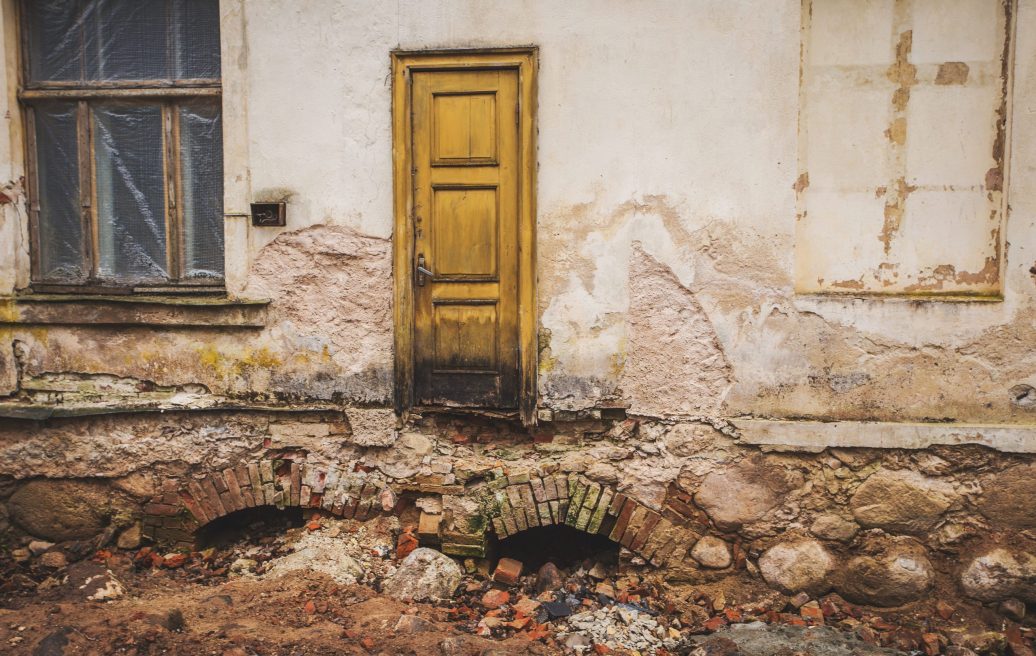 Stamerien Castle before restoration with a small wooden door with no stairs leading up to it