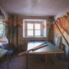 A room in Dundaga Castle before restoration, with mottled murals and tattered furniture