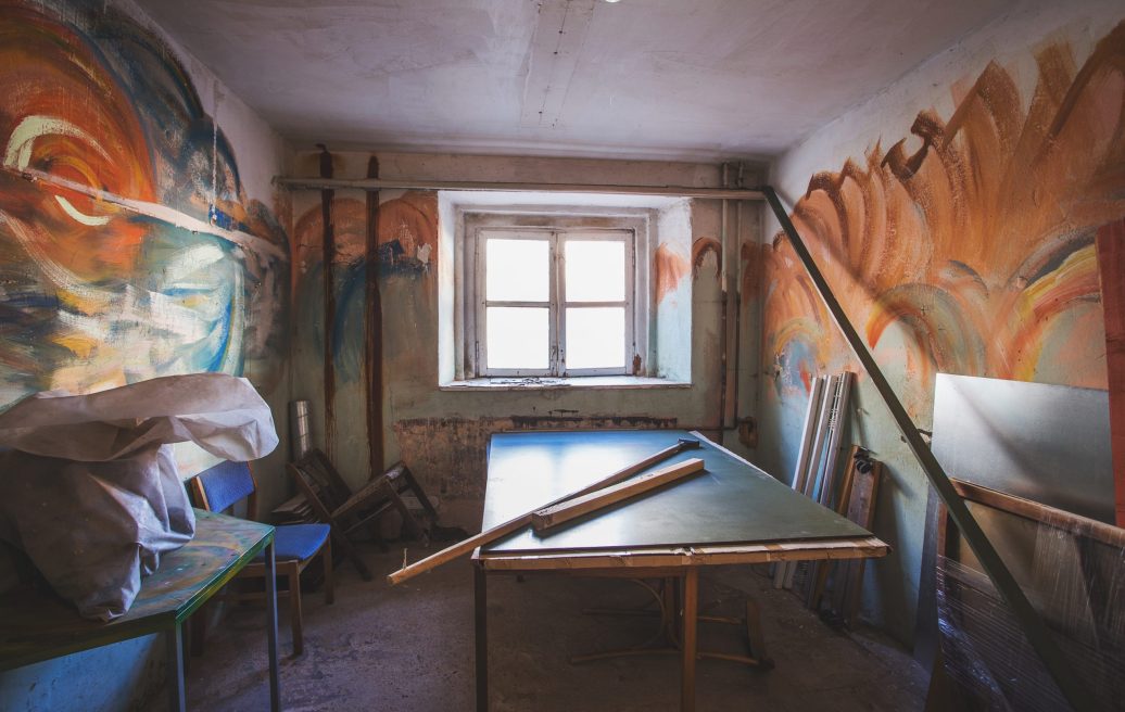 Dundagas pils telpa pirms atjaunošanas ar raibiem sienas gleznojumiem un saplēstām mēbelēm