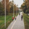Pedestrian path of Carnikava Local History Centre with people and colorful autumn leaves on trees