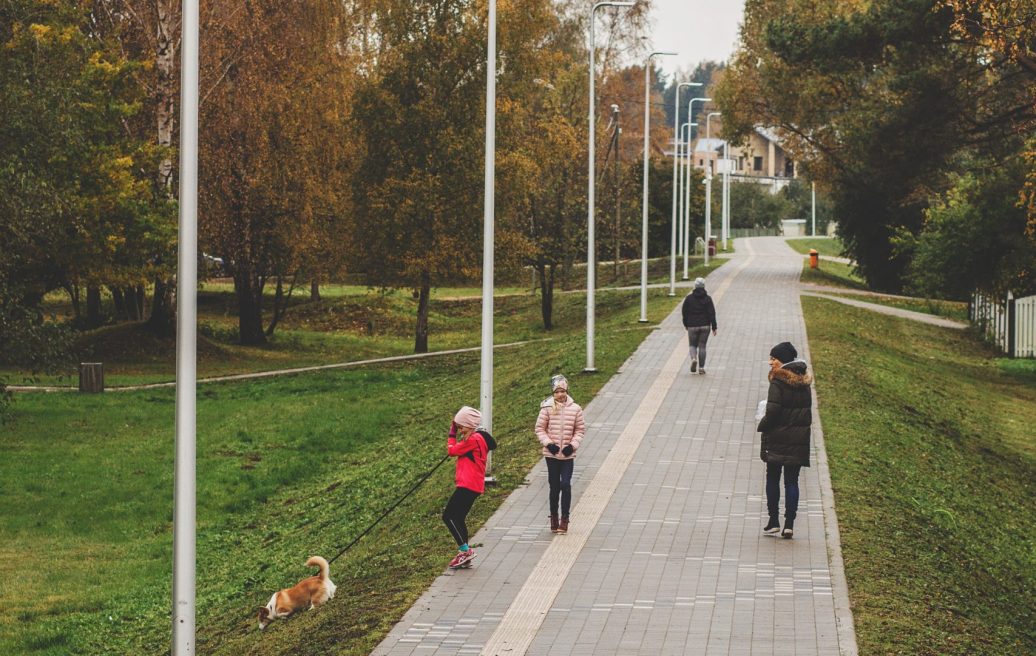 Pedestrian path of Carnikava Local History Centre with people and colorful autumn leaves on trees