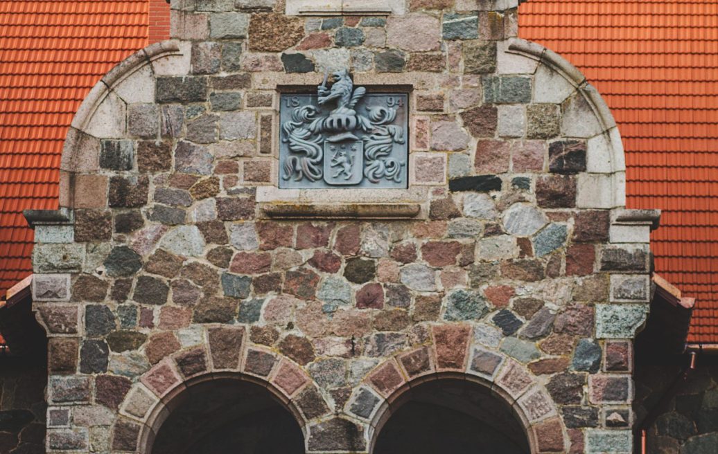 Masonry wall of Cesvaine Castle with embedded coat of arms