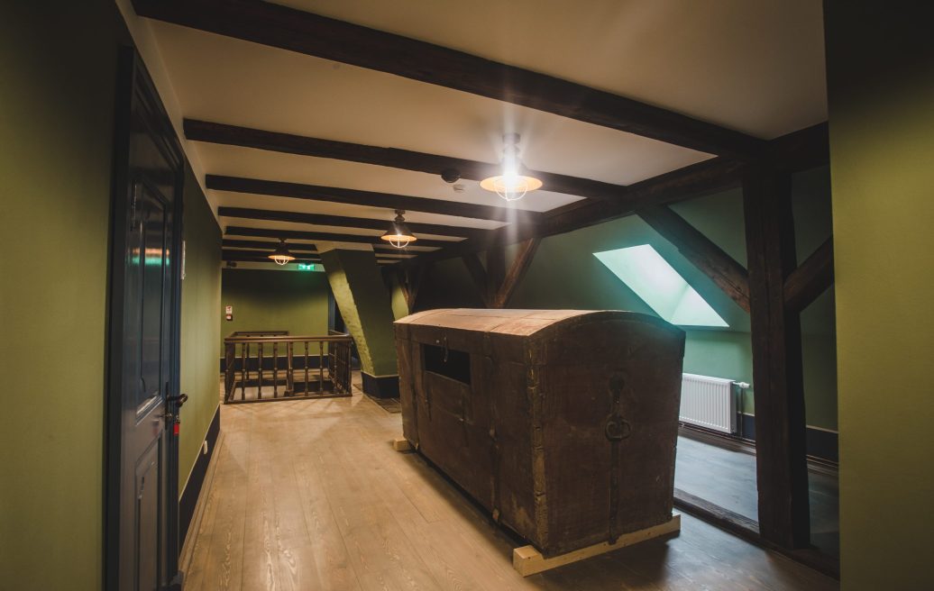 A room on the second floor of the Fircks-Pedvāle Manor Houser with green walls and a historical chest