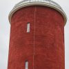 The spire of the Ķemeru water tower in close-up with the Latvian flag