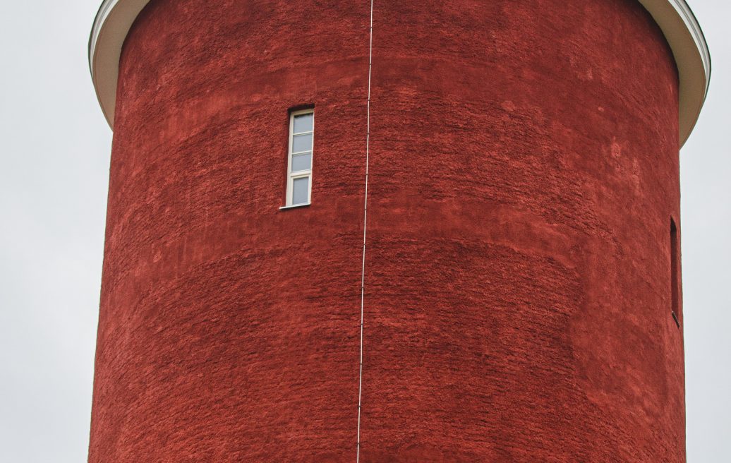 The spire of the Ķemeru water tower in close-up with the Latvian flag