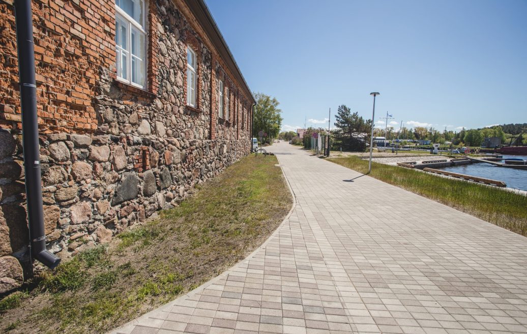 Ceļs, kas ved gar Pāvilostas pretplūdu promenādi vasarā