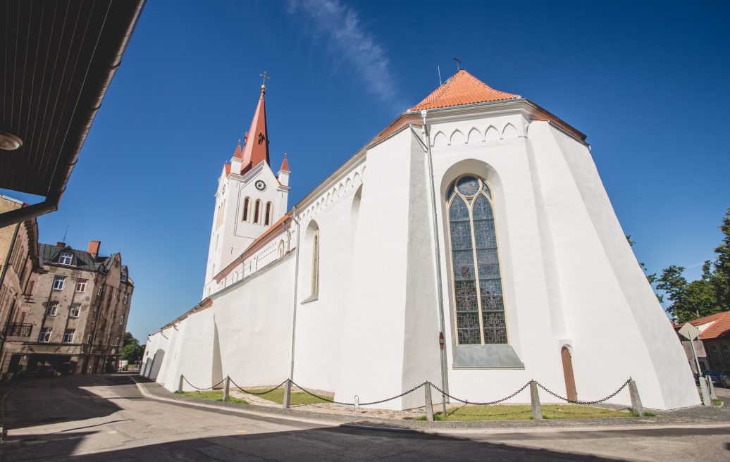 Cēsu Sv. Jāņa baznīcas logs un baznīcas ēka baltā krāsā