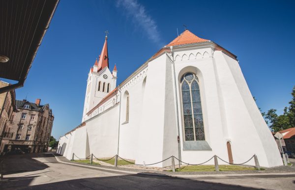 Cēsu Sv. Jāņa baznīcas logs un baznīcas ēka baltā krāsā