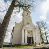 Rubene Evangelical Lutheran Church in a beautiful picture from the outside, with trees and blue sky in the background