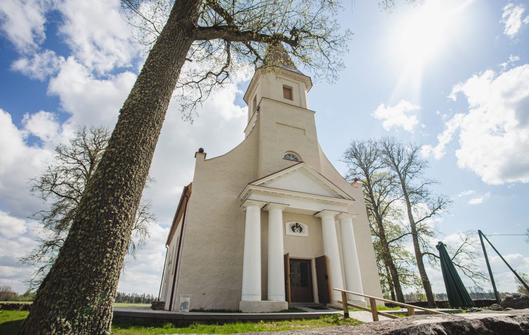 Rubene Evangelical Lutheran Church in a beautiful picture from the outside, with trees and blue sky in the background