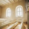 The white room of the Rubene Evangelical Lutheran Church showing windows, white seats, colonnades