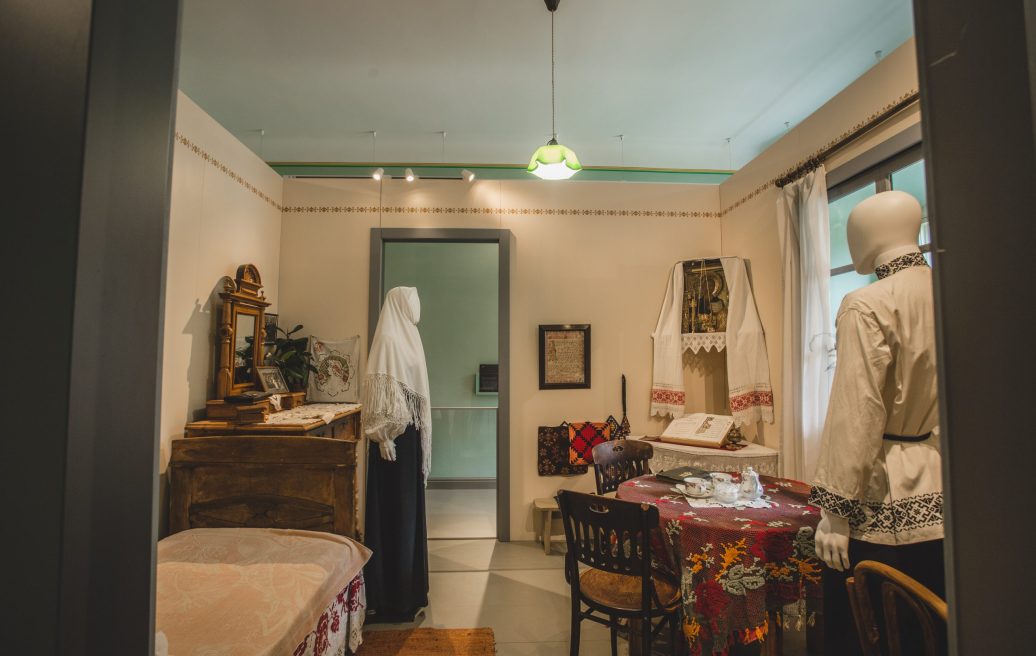 Krustpils Palace room with ancient clothing, chest of drawers, bed, table, chairs and prayer corner