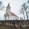 Rubene Evangelical Lutheran Church with a fence and trees around