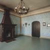 Krustpils Palace lounge with a fireplace and blue wallpaper with an ornate pattern