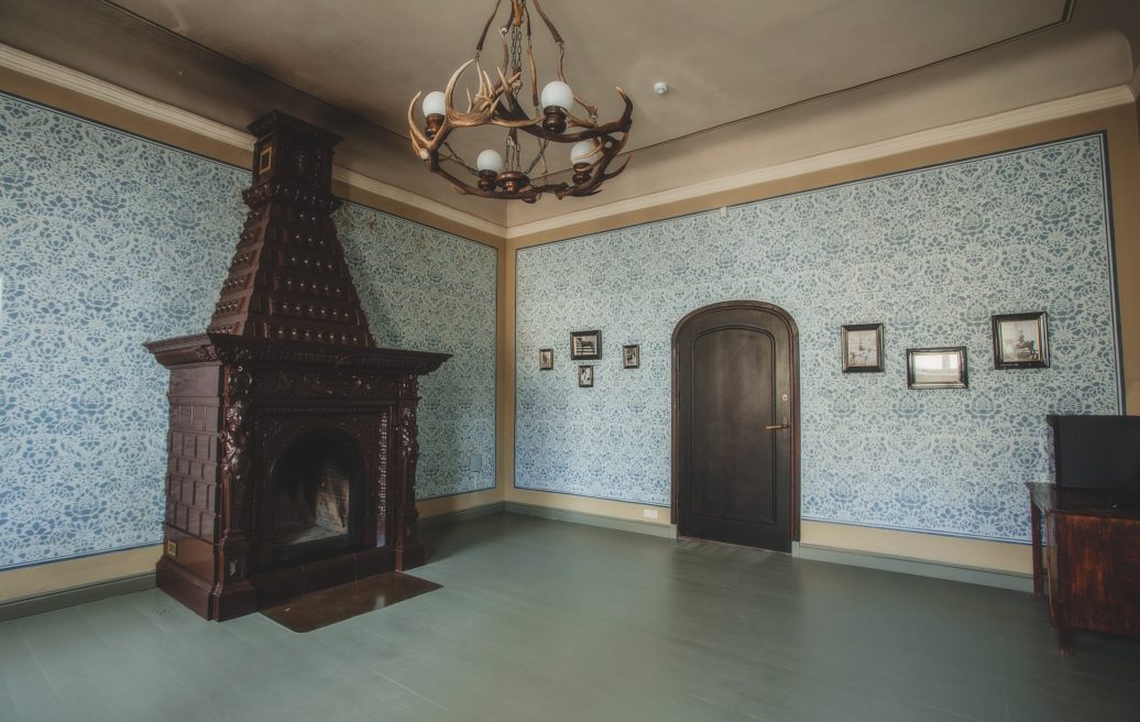 Krustpils Palace lounge with a fireplace and blue wallpaper with an ornate pattern