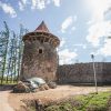 View of the Northern Tower of Ērģeme Medieval Castle with an attached tower roof and a fence that cannot be crossed