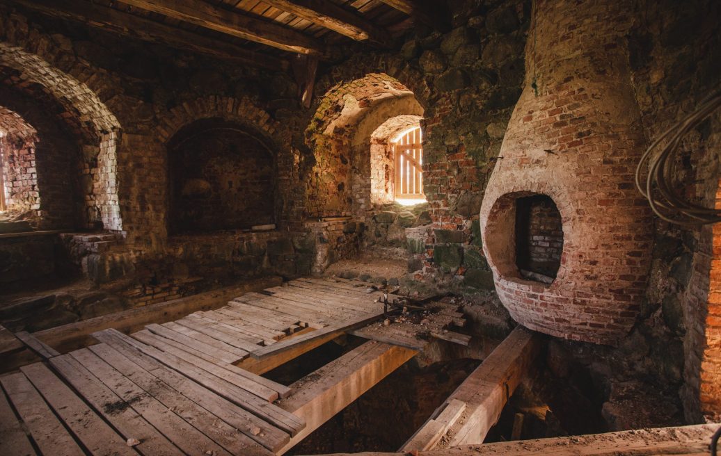 The interior of the Northern Tower of Ērģeme Medieval Castle with wooden floors and a window