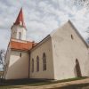 The building of the Smiltene Evangelical Lutheran Church with a white finish and a brown roof