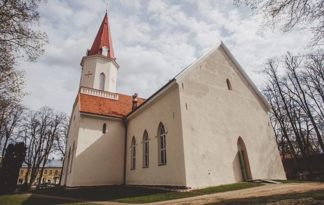 The building of the Smiltene Evangelical Lutheran Church with a white finish and a brown roof