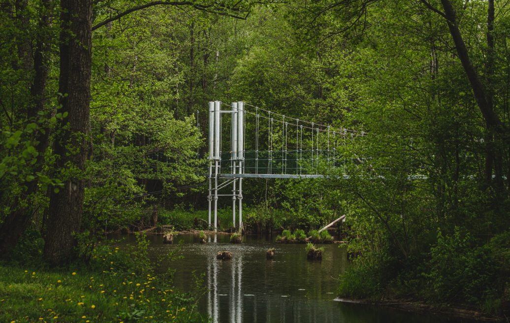 Footbridge over the Irbe river in the landscape