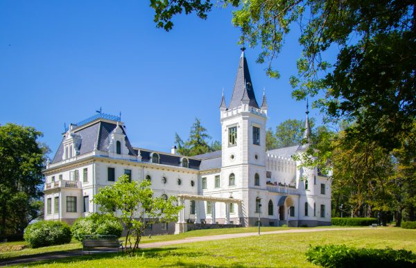Stāmerien Castle after renovation with white exterior and dark blue roof